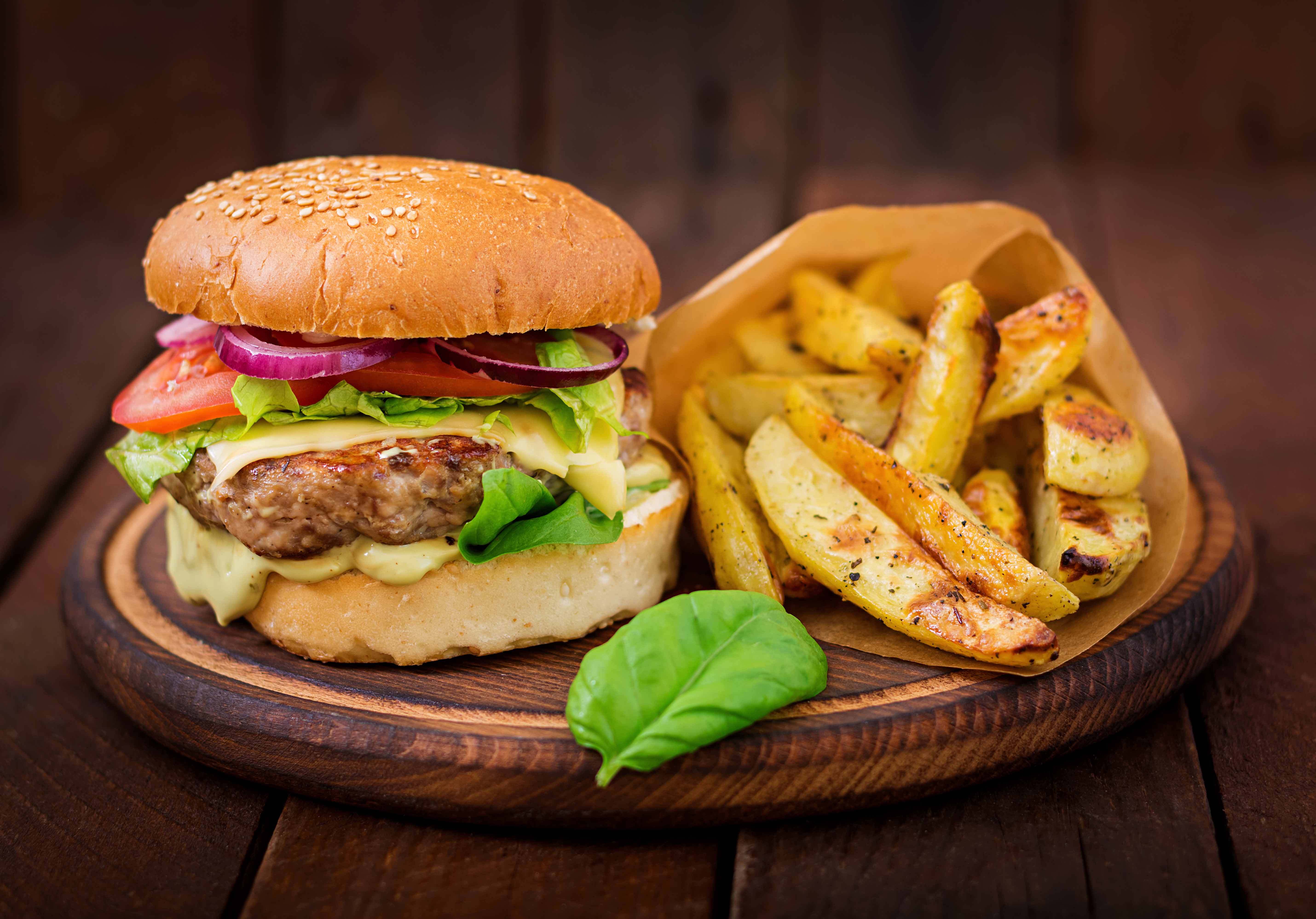 Hamburguesa con queso Mar del Plata. tomate, lechuga y cebolla morada acompañado de papas rusticas